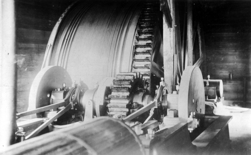 This photograph taken circa 1860 shows a large wheel wound with heavy cable, which is most likely used to pull mining cars to and from the site. There is a smaller gear that is propelled by the engine in the bottom left of the image. | UVM Landscape Change Program